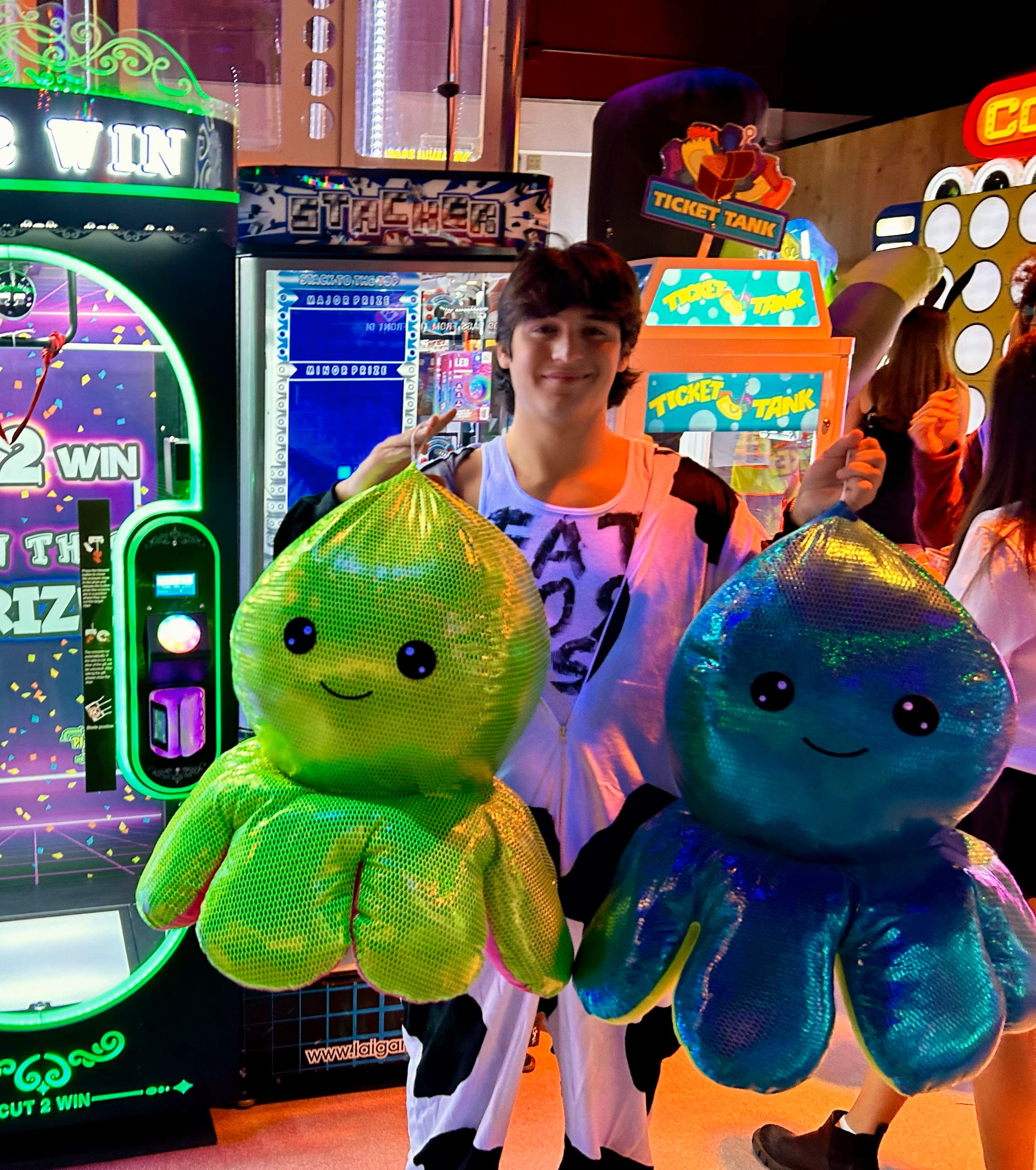 A guest celebrating with large arcade prizes