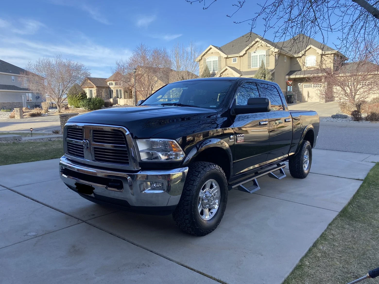 Glossy black RAM pickup parked in a driveway after detailing